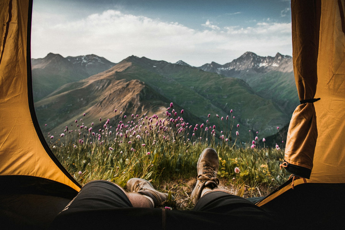 Persona dentro de una tienda de campaña mirando la montaña — Kits de supervivencia Ferrata Outdoor